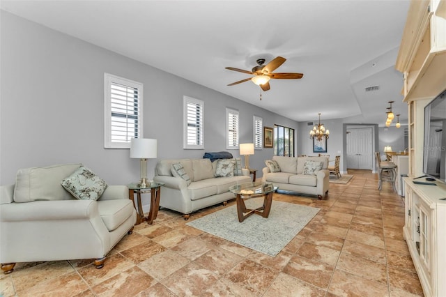 living room featuring ceiling fan with notable chandelier