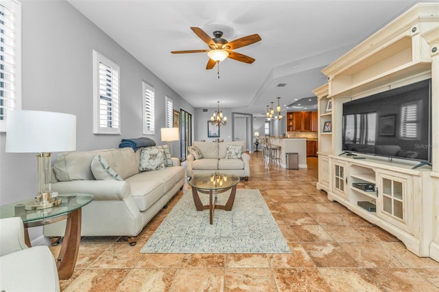 living room featuring ceiling fan with notable chandelier