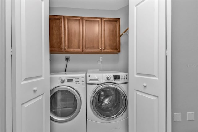 laundry room featuring cabinets and washing machine and dryer