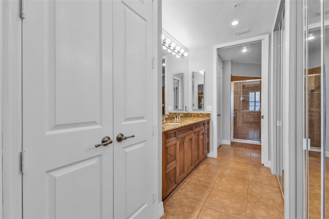 bathroom with tile patterned flooring, vanity, and an enclosed shower