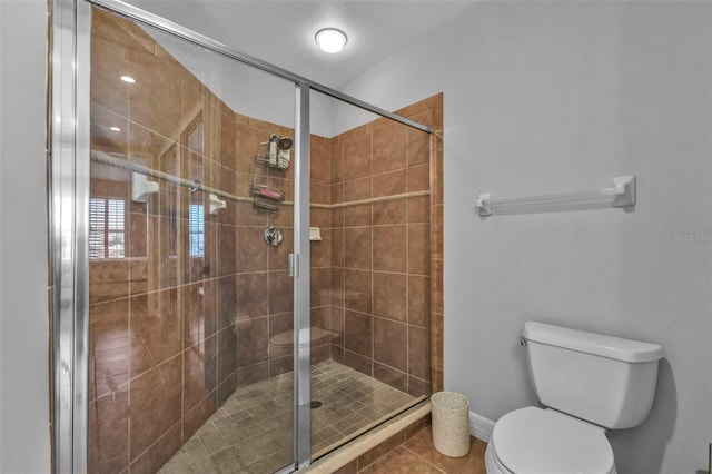 bathroom featuring tile patterned floors, toilet, and an enclosed shower