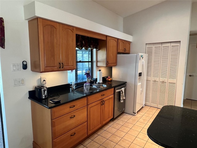 kitchen featuring stainless steel dishwasher, light tile patterned floors, refrigerator with ice dispenser, and sink