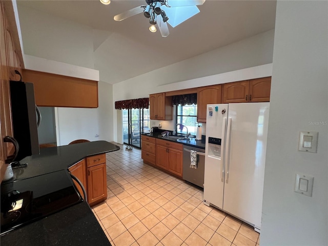 kitchen featuring white refrigerator with ice dispenser, sink, vaulted ceiling, ceiling fan, and stainless steel dishwasher