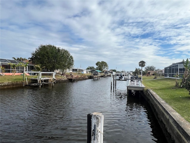 dock area featuring a lawn and a water view