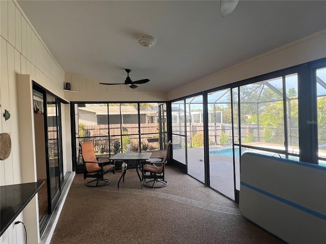 unfurnished sunroom with ceiling fan