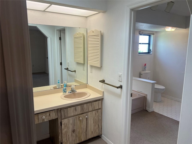 bathroom featuring toilet, tile patterned flooring, a washtub, and vanity