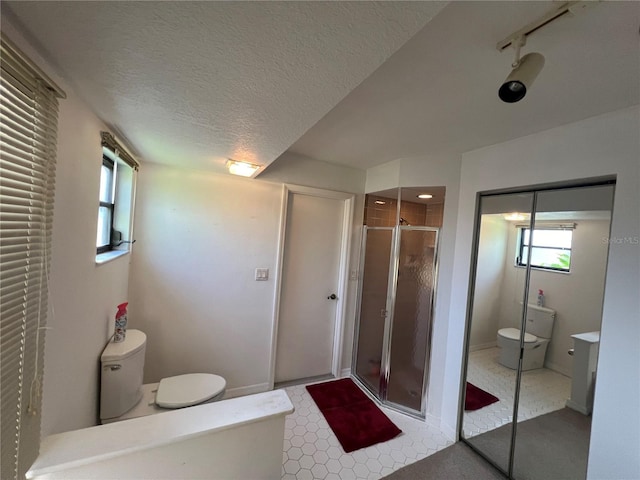 bathroom featuring a textured ceiling, toilet, and walk in shower