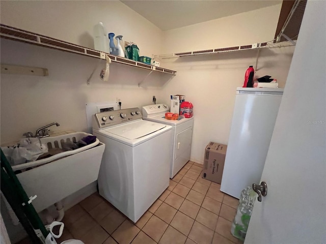 washroom featuring washer and clothes dryer, sink, and light tile patterned floors