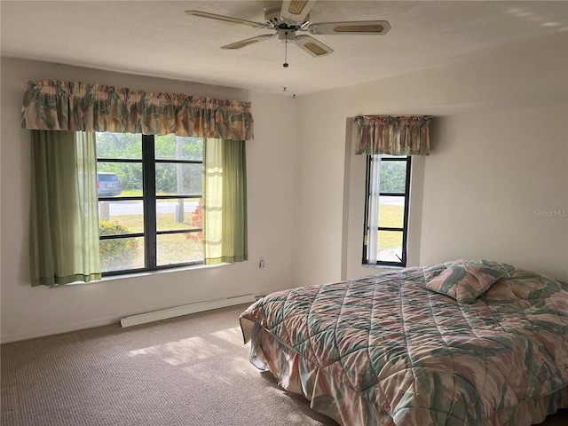 carpeted bedroom featuring ceiling fan and a baseboard heating unit