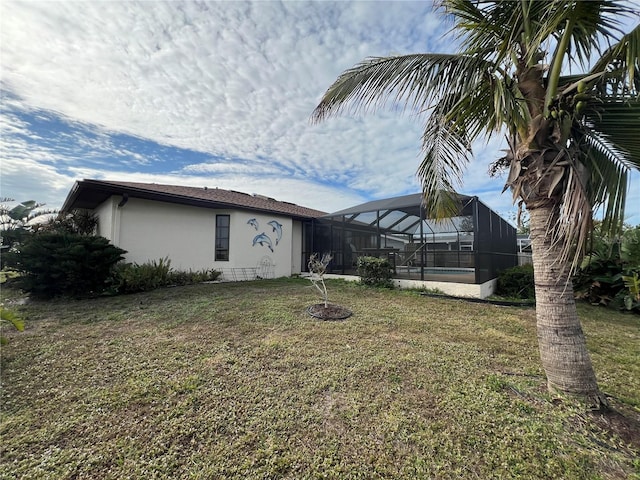 rear view of house with a lanai, a yard, and a swimming pool