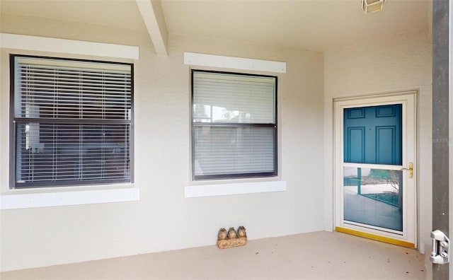 doorway to property featuring stucco siding