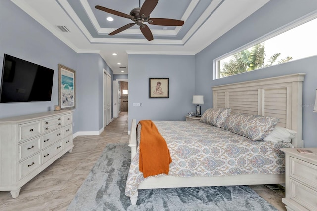 bedroom with a raised ceiling, crown molding, ceiling fan, and a closet