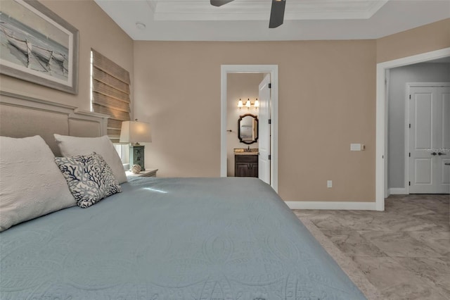 carpeted bedroom featuring a raised ceiling, ensuite bathroom, crown molding, and ceiling fan