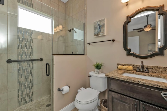 bathroom featuring ceiling fan, vanity, toilet, and a shower with door