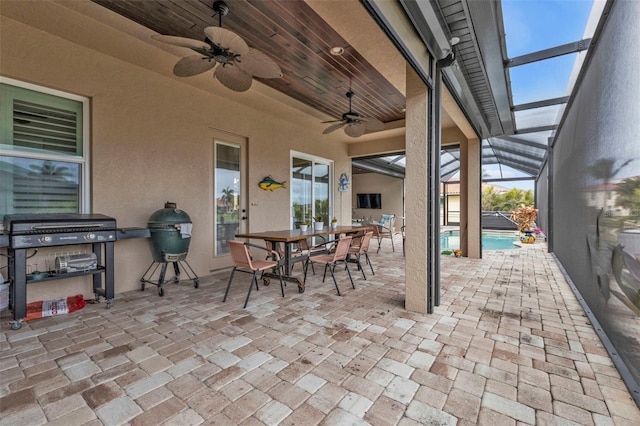 view of patio / terrace featuring a grill, ceiling fan, and glass enclosure