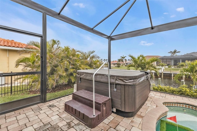 sunroom with a hot tub and a water view