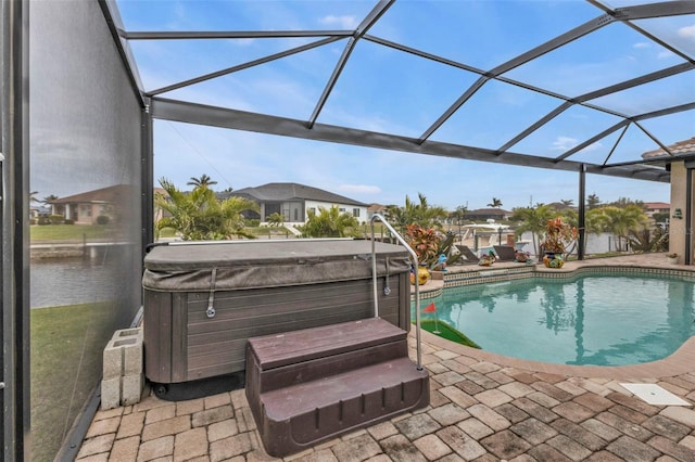 view of pool with a hot tub, a patio area, and glass enclosure