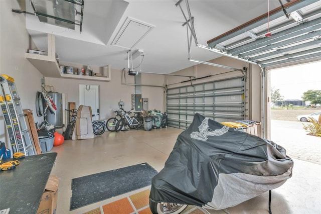 garage featuring a garage door opener, electric panel, and water heater