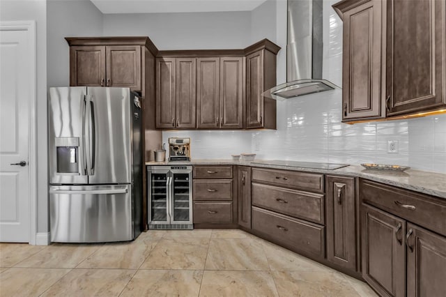 kitchen featuring beverage cooler, stainless steel fridge with ice dispenser, dark brown cabinets, black electric cooktop, and wall chimney exhaust hood