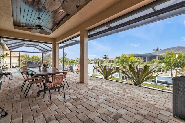 view of patio / terrace with a jacuzzi, ceiling fan, and glass enclosure