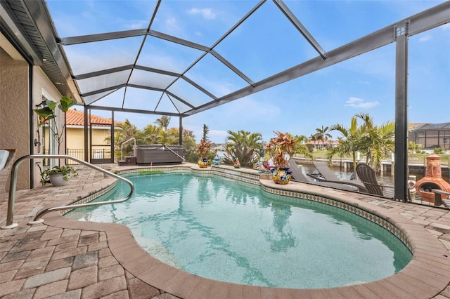 view of pool with a hot tub, a patio area, and a lanai