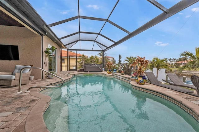 view of pool with a hot tub, a patio, and glass enclosure