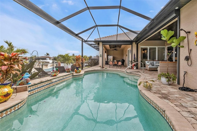 view of swimming pool featuring an outdoor living space, a lanai, a patio area, and ceiling fan