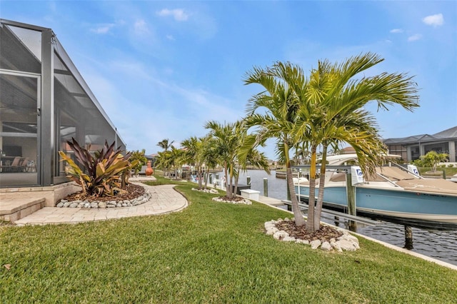 view of yard featuring a water view, a lanai, and a dock