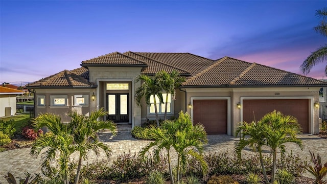 mediterranean / spanish house with a garage and french doors