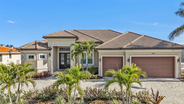 mediterranean / spanish-style home with french doors and a garage