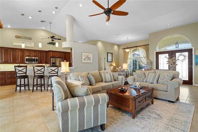 tiled living room with ceiling fan and high vaulted ceiling