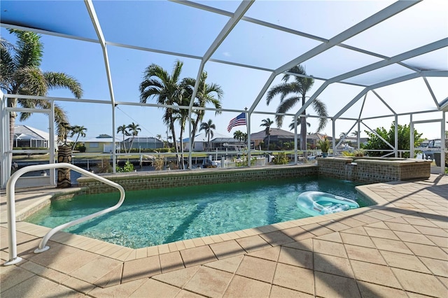 view of swimming pool featuring glass enclosure and a patio