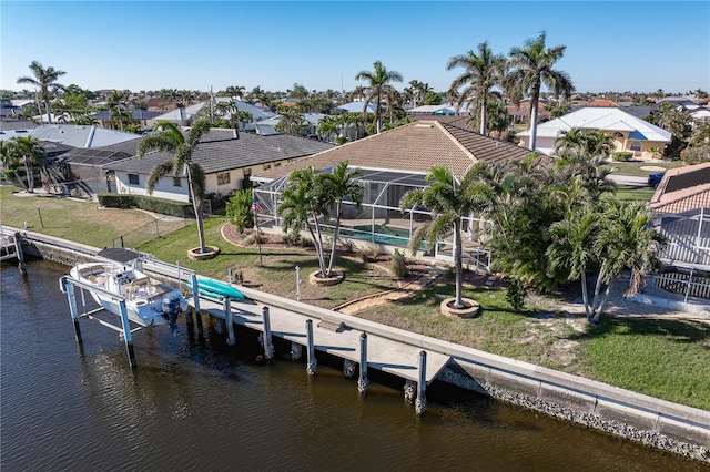 dock area featuring a yard, a water view, and glass enclosure