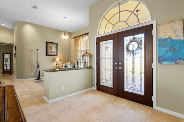 entrance foyer with a barn door, a wealth of natural light, and french doors