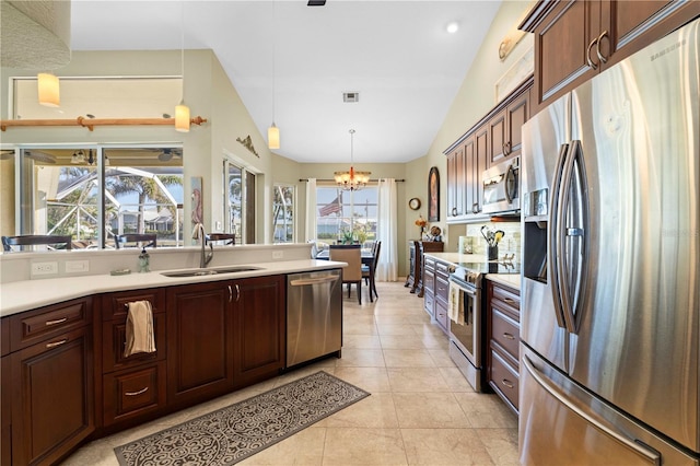 kitchen with sink, stainless steel appliances, an inviting chandelier, pendant lighting, and lofted ceiling