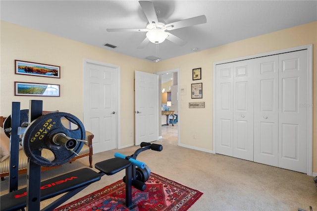 exercise area with ceiling fan and light colored carpet