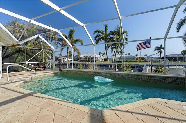 view of swimming pool featuring a water view, a patio area, and a lanai