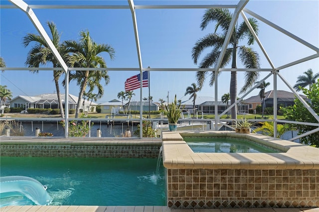 view of swimming pool featuring a lanai, an in ground hot tub, and a water view