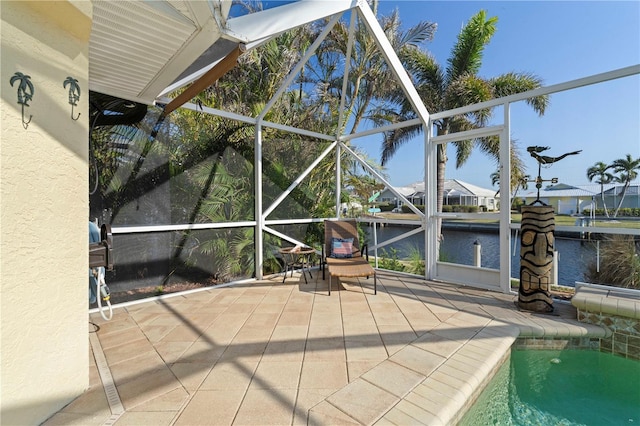 view of patio / terrace featuring glass enclosure and a water view