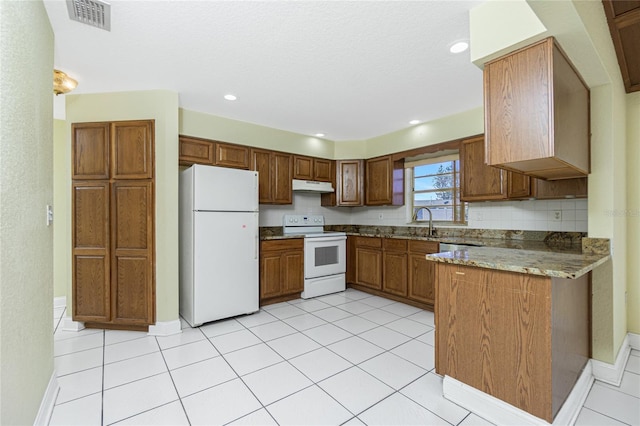 kitchen with light stone countertops, white appliances, tasteful backsplash, sink, and light tile patterned floors