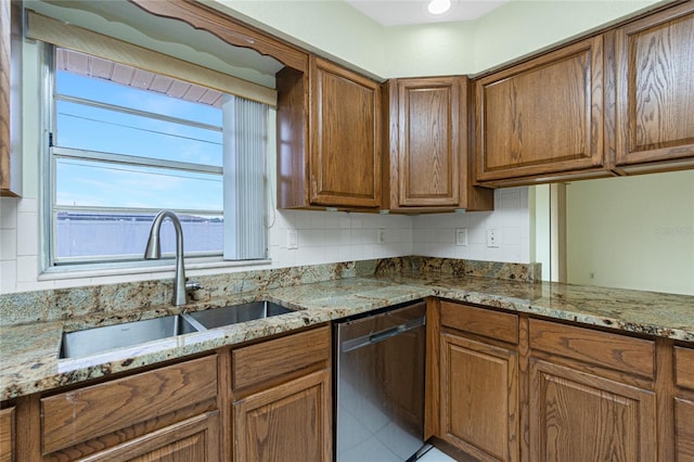 kitchen with light stone countertops, sink, dishwasher, and tasteful backsplash