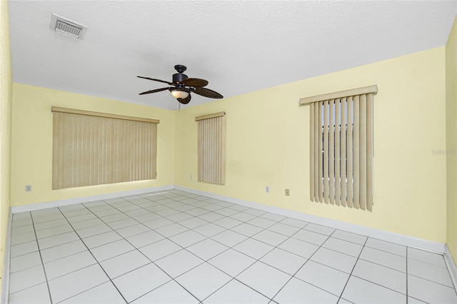 tiled spare room featuring ceiling fan and a textured ceiling