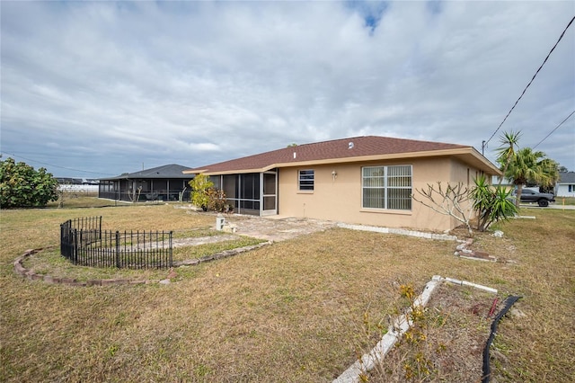 rear view of property with a sunroom and a yard