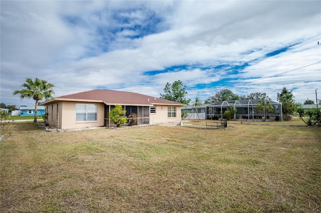 rear view of house with a lanai and a lawn