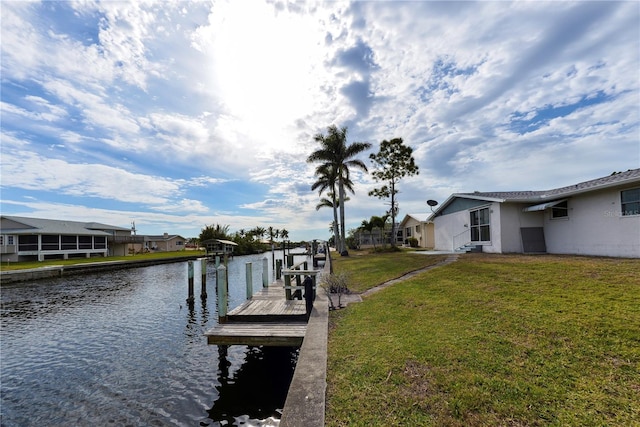 dock area with a lawn and a water view