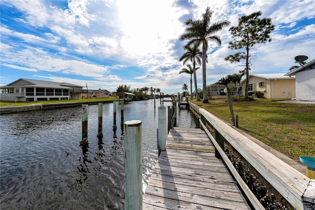 dock area with a lawn and a water view