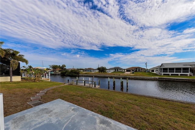 view of dock with a yard and a water view