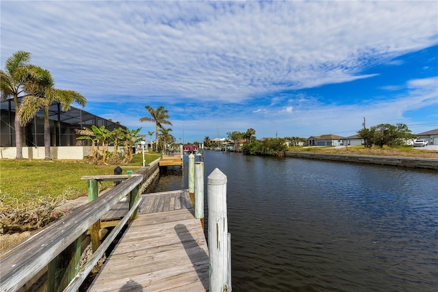 dock area featuring a lawn and a water view