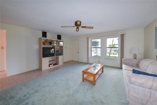 living room with ceiling fan, tile patterned flooring, and a textured ceiling