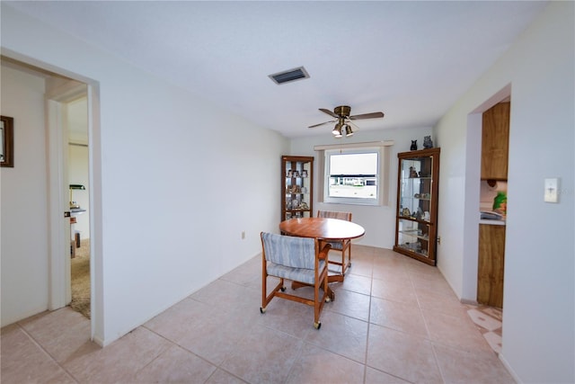 tiled dining space with ceiling fan